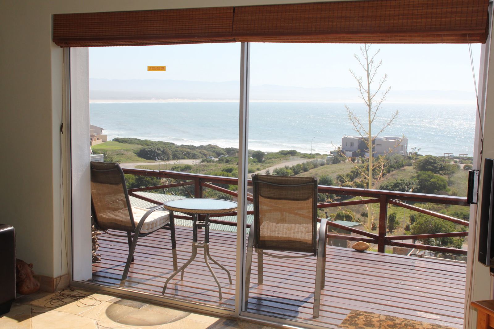 Tubes lounge opening onto the deck, with Jeffreys Bay and the surf beyond
